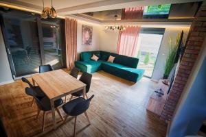 a living room with a green couch and a table at Na Skraju Raju in Zator