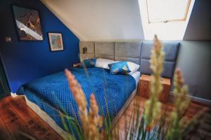 a blue bedroom with a bed with blue sheets at Na Skraju Raju in Zator