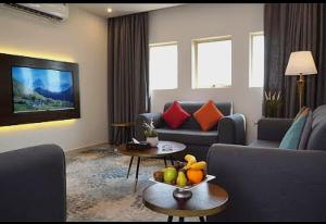 a living room with a couch and a table with a bowl of fruit at Azard Hotel in Al Madinah