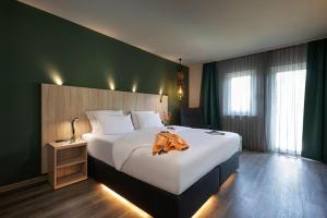 une chambre d'hôtel avec un lit et un peignoir dans l'établissement ACHAT Hotel Reilingen Walldorf, à Reilingen