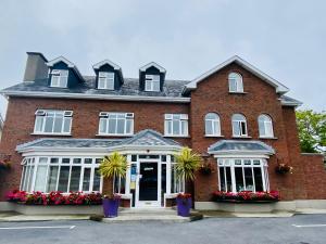 a brick house with flowers in front of it at St. Judes Lodge B&B in Galway