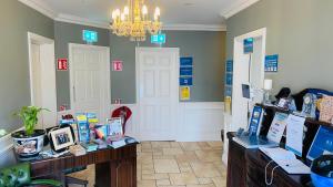 a room with a chandelier and a table with books at St. Judes Lodge B&B in Galway