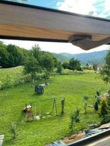 Blick auf ein Feld mit einem Zelt und einem Spielplatz in der Unterkunft Ranch Diamond Sarajevo in Vogošća