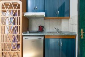 a kitchen with blue cabinets and a sink at Fay Boutique Hotel in Toroni