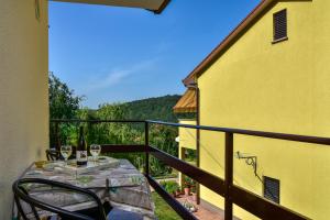 einen Balkon mit einem Tisch und Weingläsern darauf in der Unterkunft Apartman Koraca in Roč