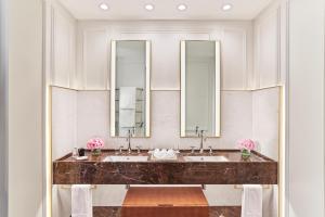 a bathroom with two sinks and two mirrors at Mandarin Oriental, Ritz Madrid in Madrid
