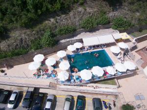 an overhead view of a swimming pool with white umbrellas at Nymfes Hotel in Kato Loutraki