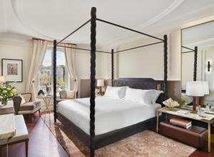 a bedroom with a four poster bed and a living room at Mandarin Oriental, Ritz Madrid in Madrid