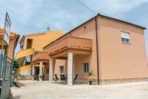 a building with chairs and tables outside of it at Apartman Joso in Sukošan