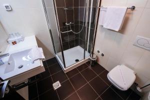 uma casa de banho com um chuveiro, um WC e um lavatório. em Hotel Terra em Novalja