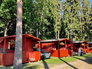 a row of orange cabins parked in a forest at Vaibla Holiday Center in Vaibla
