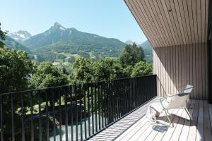 a balcony with a chair and a view of mountains at Amrai Suites in Schruns-Tschagguns