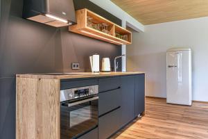 a kitchen with a stove and a refrigerator at Landhotel und Apartments Sonneck in Feldberg