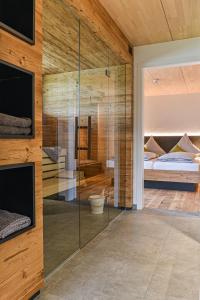 ein Schlafzimmer mit Glaswänden und einem Bett und ein Schlafzimmer mit einem Bett in der Unterkunft Landhotel und Apartments Sonneck in Feldberg