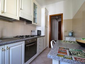 a kitchen with white cabinets and a stove top oven at Residenza Parco Ducale 2 in Parma +2 photos