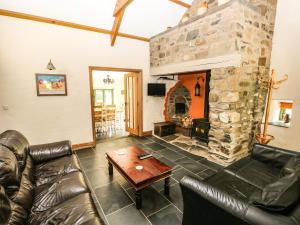 a living room with a couch and a stone fireplace at Trewrach Cottage in Newport