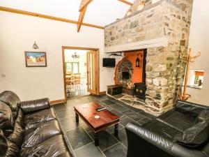a living room with a couch and a stone fireplace at Trewrach Cottage in Newport Pembrokeshire