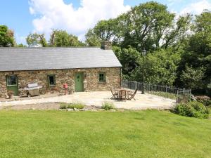 a stone cottage with a picnic table in the yard at Trewrach Cottage in Newport Pembrokeshire
