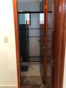 a bathroom with a shower with a glass door at Apartamento solar vitória regia - Frente Mar in Praia Grande +7 photos