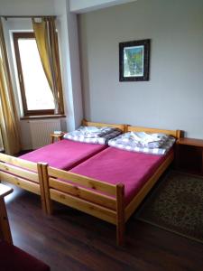 sypialnia z 2 łóżkami z purpurową pościelą i oknem w obiekcie Dom Turysty Na Skarpie w mieście Malbork