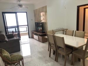 a living room with a dining room table and chairs at Apartamento solar vitória regia - Frente Mar in Praia Grande
