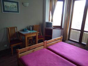 sypialnia z łóżkiem z różowym kocem w obiekcie Dom Turysty Na Skarpie w mieście Malbork