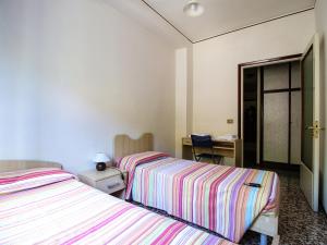 een slaapkamer met 2 bedden en een bureau met een spiegel bij Residenza Parco Ducale in Parma