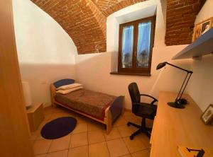 Zimmer mit einem Bett, einem Schreibtisch und einem Stuhl in der Unterkunft Appartamento G&G in Carpignano Sesia