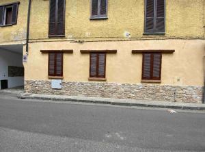ein gelbes Gebäude mit braunen Fensterläden auf einer Straße in der Unterkunft Appartamento G&G in Carpignano Sesia