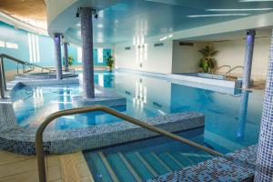 a large swimming pool with blue water in a building at Horse & Jockey Hotel in Horse and Jockey