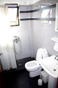 y baño con aseo, lavabo y ducha. en Popi Hotel Apartments, en Agia Marina de Nea Kydonia