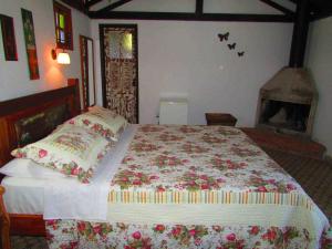 um quarto com uma cama grande com flores em Pousada Pe da Serra em Tiradentes