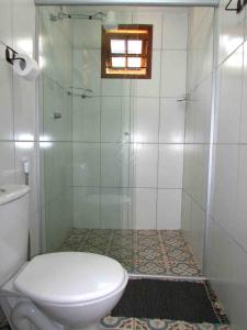 a bathroom with a shower and a toilet at Pousada Pe da Serra in Tiradentes