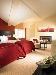 a large bedroom with red pillows and a fireplace at Horse & Jockey Hotel in Horse and Jockey