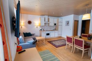 eine Küche und ein Wohnzimmer mit Sofa und Tisch in der Unterkunft Die Nockalm in Turracher Hohe