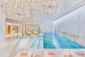 - une piscine dans une pièce dotée d'un lustre dans l'établissement Mandarin Oriental Ritz, Madrid, à Madrid