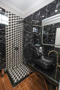 a black and white bathroom with a sink and a mirror at Hotel Peroni in Korçë