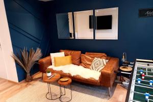 a living room with a brown couch and a blue wall at Villa Auxerre luxe Piscine Intérieure proche Paris sans Vis-à-vis in Auxerre