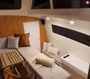 mały pokój z łóżkiem i stołem w obiekcie Barco Casa Catamarã Sleepandboat w Faro