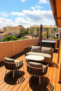 d'un balcon sur le toit avec une table et des chaises. dans l'établissement Hôtel & Spa Rocabella, à LʼÎle-Rousse