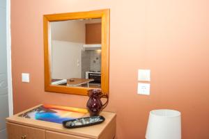 a mirror on a dresser with a remote control at Folies in Lourdata