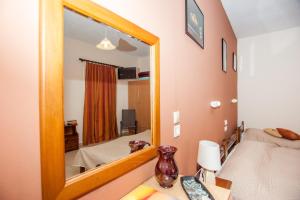 a small bedroom with a mirror and a bed at Folies in Lourdata