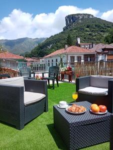 un patio con sillas y una mesa con un plato de comida en Hotel Rural Cabrales, en Carreña