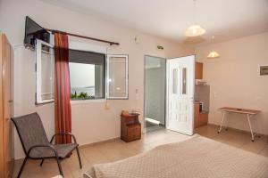 a bedroom with a bed and a chair and a window at Folies in Lourdata