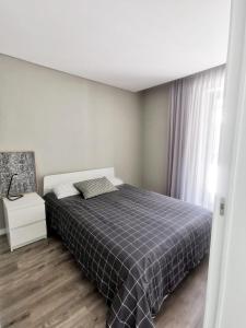 1 dormitorio con 1 cama con manta de cuadros azul en Pateo 780, en Vila Nova de Gaia