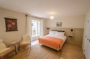 ein Schlafzimmer mit einem Bett, einem Stuhl und einem Fenster in der Unterkunft Rookery Lane Food and Lodging in Kenmare