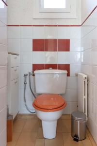 La salle de bains est pourvue de toilettes et d'un couvercle rouge. dans l'établissement Le clos Bourgogne 71, à Paray-le-Monial