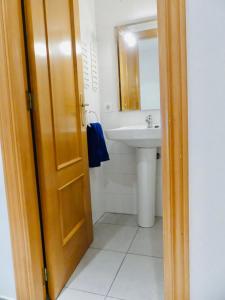 a bathroom with a sink and a wooden door at Confortable PIS en ple centre de Vic APTGARBI in Vic