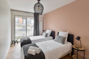 - 2 lits dans une chambre avec fenêtre dans l'établissement L'Eden - Appartement familial au pied du Thabor, à Rennes