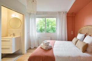 um quarto com uma cama, um lavatório e uma janela em L'Eden - Appartement familial au pied du Thabor em Rennes
